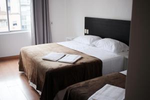 a hotel room with two beds with towels on them at Letto Business in Porto Alegre
