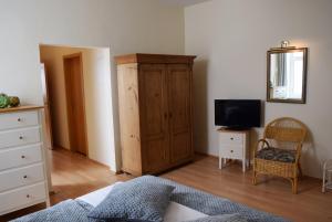 a bedroom with a wooden cabinet and a television at Fürstenhof Sassnitz in Sassnitz