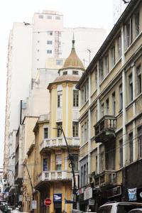 a yellow building with a turret on a city street at Letto Business in Porto Alegre