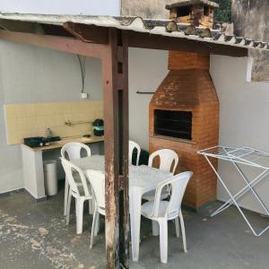 a table and chairs in a kitchen with a pizza oven at Recanto Central in Serra Negra