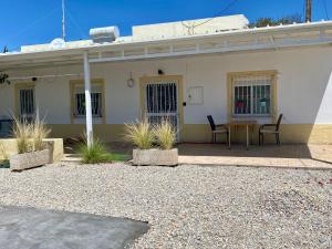 a small white house with a table and chairs at Casa Di Elsa, Lambi, Kos in Kos Town