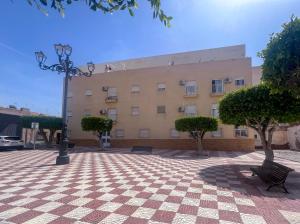 a building with a street light and trees in front of it at Roquetas Coastal Escape in Roquetas de Mar