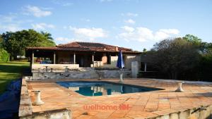 a house with a swimming pool in a yard at Chacara em Cássia com Piscina e Lago in CÃ¡ssia