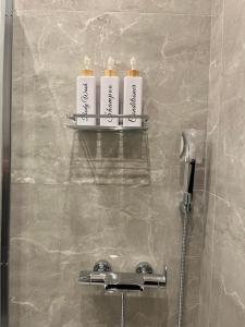 three bottles ofodorizers sit on a shelf in a shower at Skyway Comfort Residences in Spata +74 photos