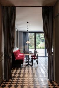 a dining room with a table and chairs and a large window at Villa V - Petit Hôtel in Valkenburg
