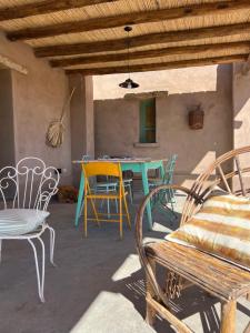 a patio with chairs and a table and a bench at Rancho de Ansilta in Barreal