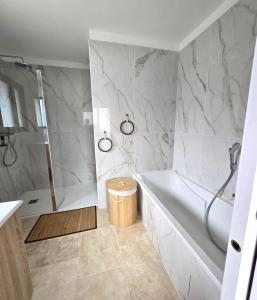 a white bathroom with a tub and a shower at Villa Bali, magnifique vue mer et Esterel in Saint-Aygulf