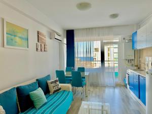 a living room with a blue couch and a table at Dolce Aqua Summerland Apartments in Mamaia