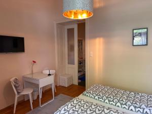 a bedroom with a bed and a table and a desk at Kristall, Doppelzimmer mit Balkon in Toplage, Zentrum in Bad Ischl