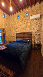 een slaapkamer met een groot bed in een stenen muur bij Beit Tout Guesthouse in Saïda