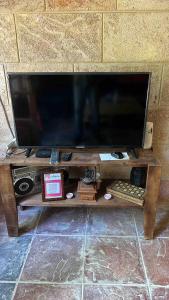 een flatscreen-tv zittend op een houten tafel bij Beit Tout Guesthouse in Saïda