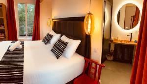 a bedroom with a bed with two pillows and a mirror at Le moulin du Guy, proche du Puy duFou in La Ménie