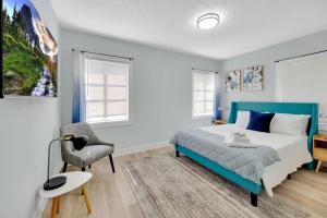 a bedroom with a blue bed and a chair at SMV Updated Bungalow Bliss Central in Jacksonville