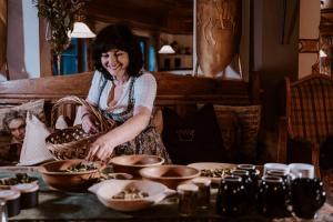 eine Frau steht an einem Tisch und bereitet Essen vor in der Unterkunft Hotel Bergschlössl in Lüsen