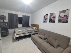 a living room with a couch and a bed at Casa Mineira - Flats novos em Ponta de Mangue - Maragogi in Maragogi +52 photos