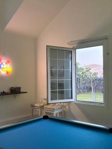 ein Zimmer mit Billardtisch und Fenster in der Unterkunft Prairie in Al Khaznah