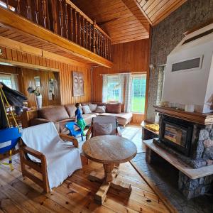 a living room with a table and a fireplace at Domek Malina in Nadole