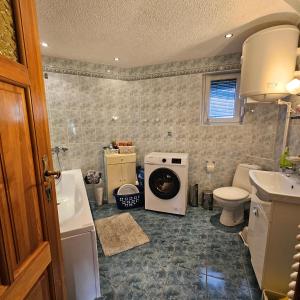 a bathroom with a washer and dryer on the floor at Domek Malina in Nadole +23 photos