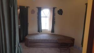 a bedroom with a bed in front of a window at Kheya Kutir in Shānti Niketan