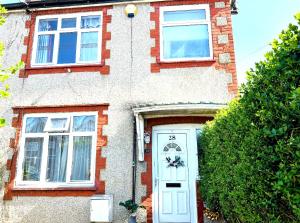 a brick house with a white door and two windows at MASTER Bedroom in Feltham
