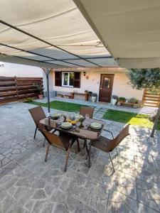 a table and chairs under an umbrella on a patio at Casa a 7 minuti da aeroporto FCO vicino fiera di Roma!! in Fiumicino