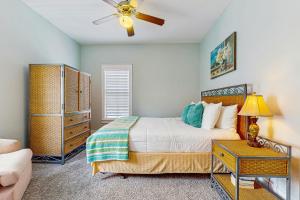 Un dormitorio con una cama y un ventilador de techo. en Barefoot Cottages #B16, en Highland View 16 fotos más