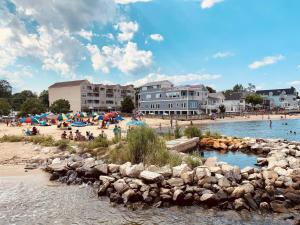 a beach with a bunch of people on the sand at Walk to the Beach! Beach Passes | Games I King Bed in North Beach