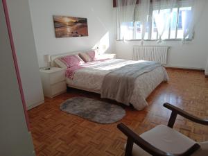 a bedroom with a bed and a chair in it at Paseo de Noia in Noya