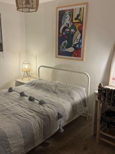 a bedroom with a bed and a painting on the wall at Cozy Room in Great Location Stockwell Clapham in London