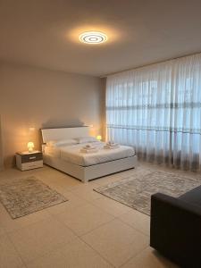 a bedroom with a bed and a large window at Ca' Monte 2 - Dimora Centrale 2 camere in Montebelluna