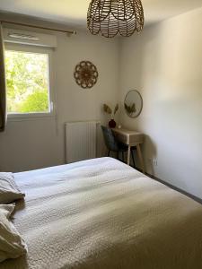 une chambre avec un lit, un bureau et une fenêtre dans l'établissement Joli appartement à Andernos les bains , 2 ou 4 pers , avec terrasse et parking, à Andernos-les-Bains