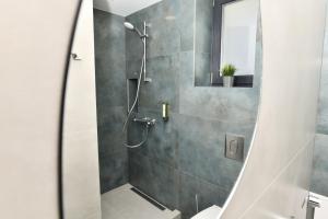 una ducha con puerta de cristal en un baño en Апартамент Инфинити, en Veliko Tŭrnovo