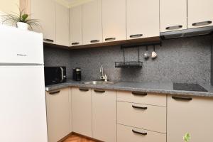 Una cocina con gabinetes blancos y un fregadero. en Апартамент Инфинити, en Veliko Tŭrnovo 28 fotos más
