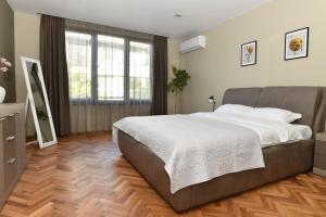 Un dormitorio con una cama grande y una ventana grande. en Апартамент Инфинити, en Veliko Tŭrnovo
