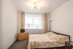 a bedroom with a bed and a dresser and a window at Nice Flats Belorusskaya in Moscow