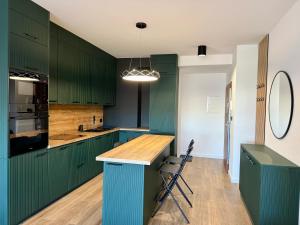 a kitchen with green cabinets and a wooden counter top at Drahan Apartment 28 in Radom