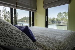 une chambre avec un lit avec vue sur l'eau dans l'établissement Amphawa Caza Platuu, à Amphawa 99 autres photos