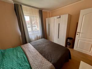 a bedroom with a bed and a large window at Top Apartment in Gheorgheni