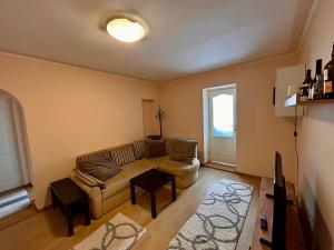 a living room with a couch and a window at City Nest by RentALL in Gheorgheni +3 photos