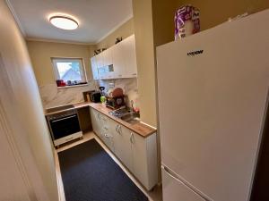 a small kitchen with a refrigerator and a sink at City Nest by RentALL in Gheorgheni