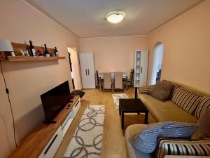 a living room with a couch and a television at Top Apartment in Gheorgheni +2 photos