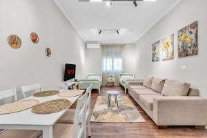 a living room with a couch and a table at "Olive & Bloom" entire vila with Pool & Private Parking in Berat +31 photos