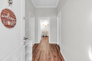 a hallway with white walls and a hard wood floor at "Olive & Bloom" entire vila with Pool & Private Parking in Berat