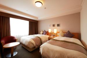 a hotel room with two beds and a window at Keio Plaza Hotel Hachioji in Hachioji