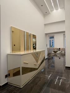 a large white room with a dresser with a mirror at Luxury Gold apartman in Budapest