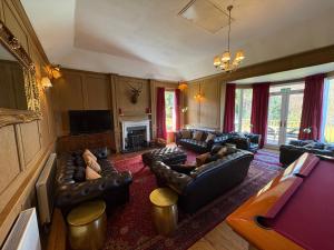Una gran sala de estar con sofás y un televisor. en Rhumhor House, en Carrick