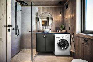 eine Waschmaschine im Bad mit Spiegel in der Unterkunft New, cozy cottage on Norefjell with stunning views in Noresund