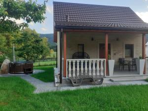 a small house with a porch and a grill at Domek Przy Zalewie Z Balią in Radków