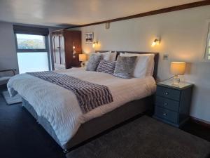 a bedroom with a large bed and a window at The Dairy at Brackenthwaite Farm in Carnforth