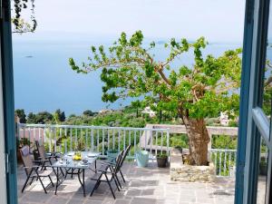 a patio with a table and chairs and a tree at Διώροφη κατοικία Γλώσσα Σκοπέλου in Skopelos Town